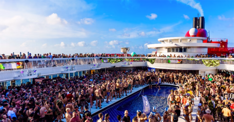 The top deck of an LGBTQ+ cruise ship. A large crowd of gay men stand around an open-air swimming pool.