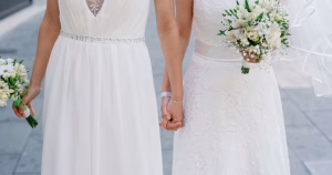 This article is about same-sex marriage in Bolivia. In the photo, two women in wedding dresses holding hands.