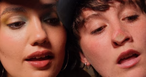 Still from social media series Fruity of characters Alice and Clarke looking through their window, pressed up against the glass.