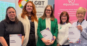 The article is about LGBT Ireland's report Hidden Barriers on LGBTQ+ people's access to mental health services. The image depicts 5 people holding the report and standing in a line at the launch event
