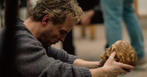 The article is about the biopic drama Elsinore about Ian Charleson. The image depicts Andrew Scott holding a skull