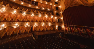 A wide shot of a theatre, showing the stage and rows of seats.