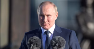 This article is about the recent election in Russia. The image shows Vladimir Putin speaking at a podium.