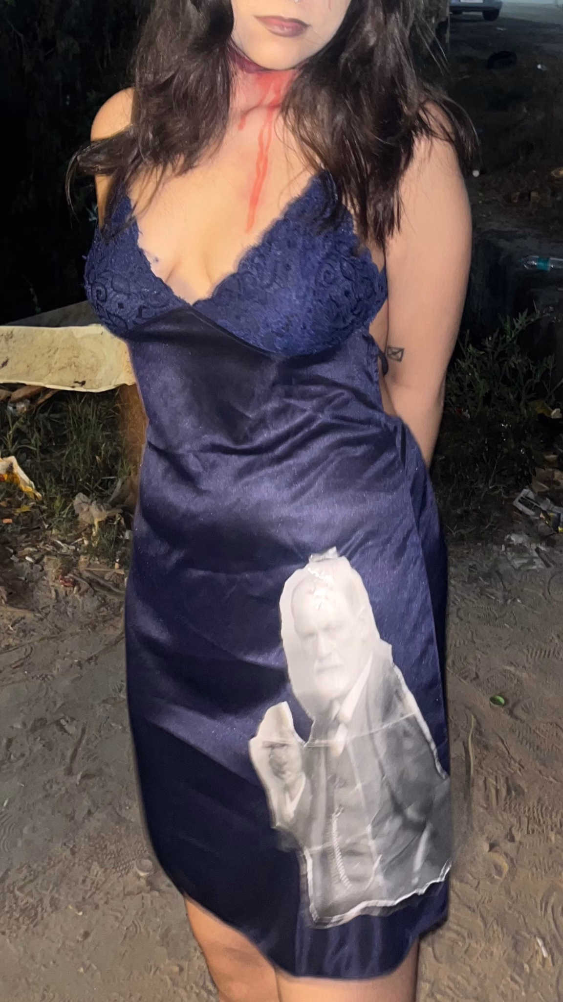 Someone wearing a blue slip dress with a cut out of Sigmund Freud attached.